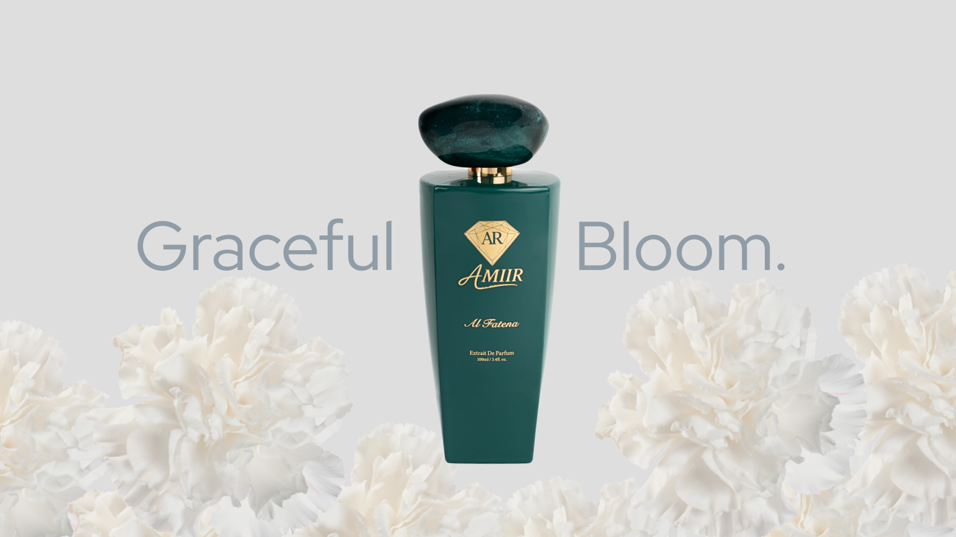 Al Fatena product shot "Graceful bloom" text on a light grey background. The Al Fatena bottle in deep green is centered, surrounded by soft white flower petals at the base. Minimal and elegant composition.