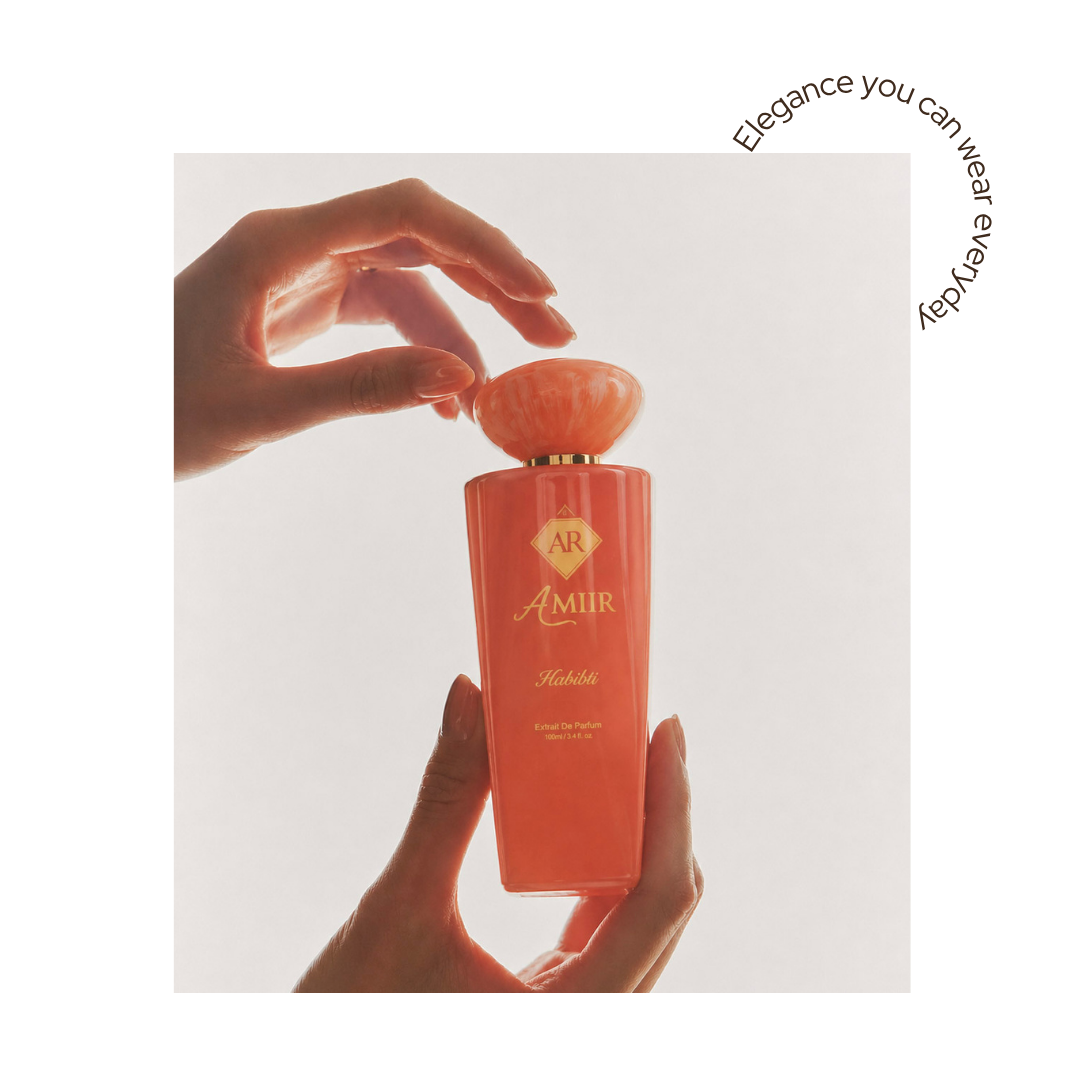 Habibti perfume bottle with 'Amir' branding held by a hand on a light background